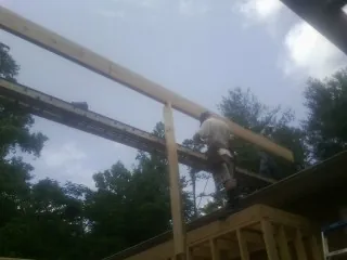 Carpenter setting a ridge beam over a new addition frame — Ice Dam Removal by Roofing Brothers in Thorofare