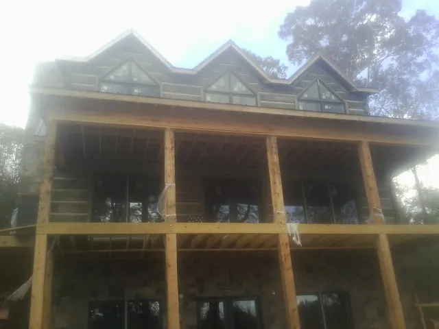 Dormers and porch framing on a large log home under construction — Roof Coating work by our crew in Thorofare